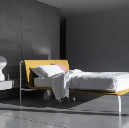 Minimal and elegant bed with fabric headboard and Bend metal structure by Bolzan Letti.