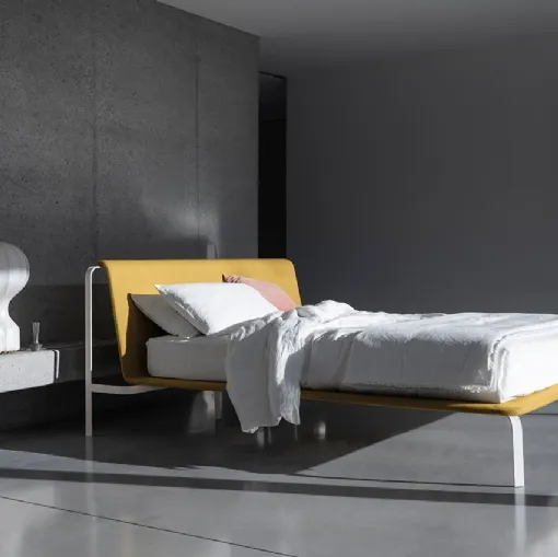 Minimal and elegant bed with fabric headboard and Bend metal structure by Bolzan Letti.