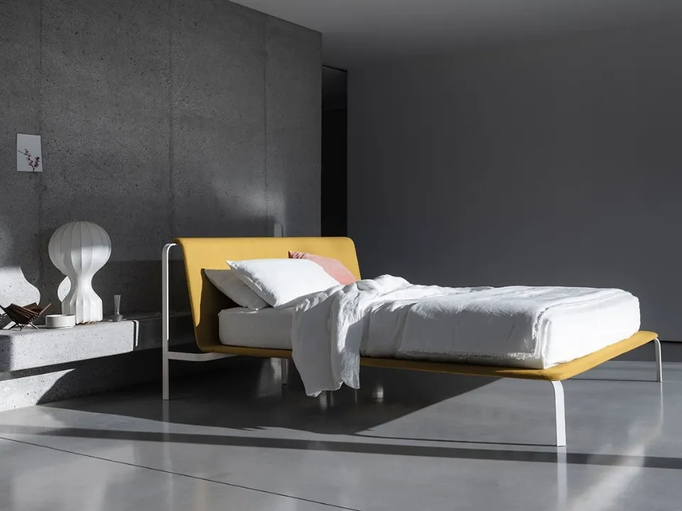 Minimal and elegant bed with fabric headboard and Bend metal structure by Bolzan Letti.