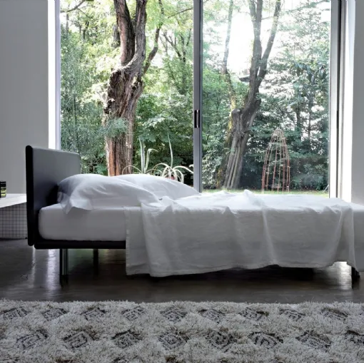 Bed with leather headboard and metal feet Milan by Zanotta.